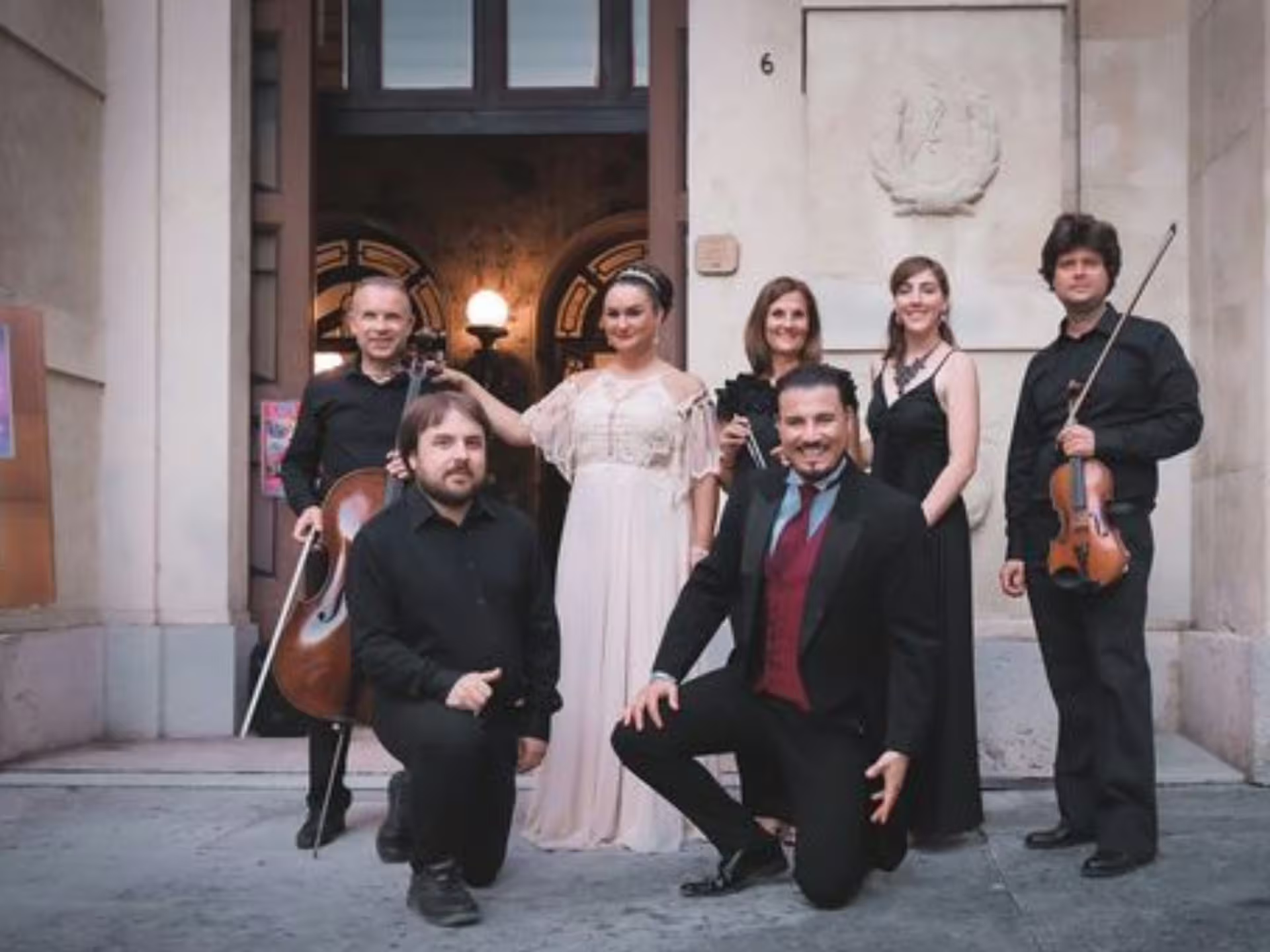Opera performers and musicians posing outside Verona Palace, a charming setting for an evening with Prosecco.