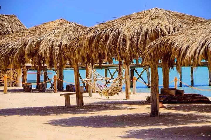 Orange Bay beach huts and hammocks on white sand, full-day boat tour from Hurghada Sahl Hasheesh Soma Bay Makadi