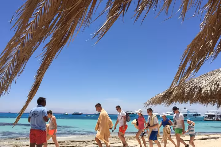 Orange Bay island tour from Hurghada with beach walk, palm shade, crystal water and boats anchored offshore