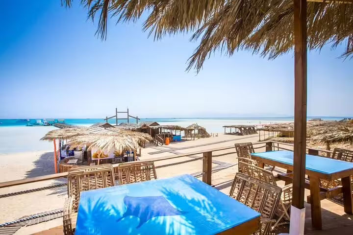 Orange Bay Island beach lounge with shaded huts and sea view on VIP boat day trip from Hurghada