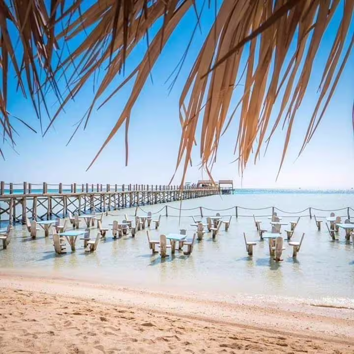 Orange Bay Island Hurghada pier with overwater tables in crystal-clear Red Sea lagoon and sandy beach