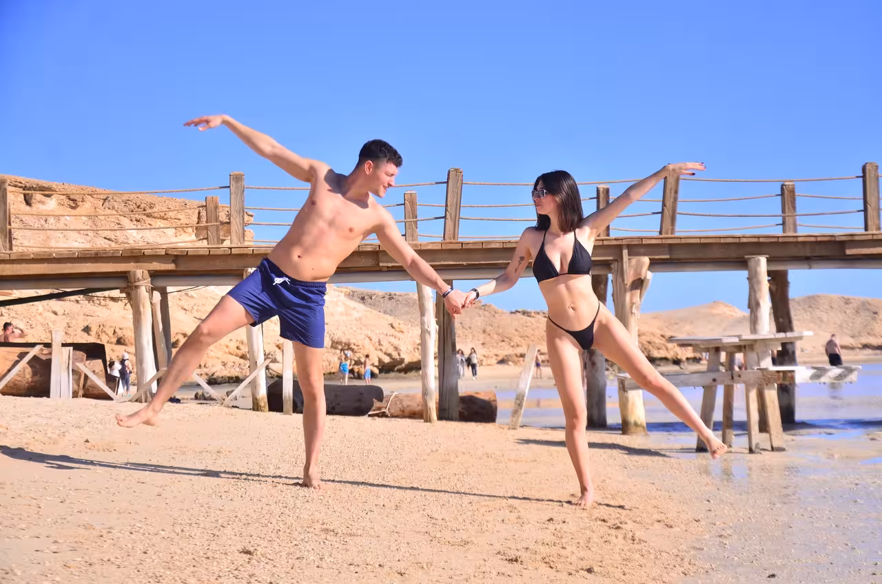 Couple dancing on sandy Orange Bay Island shore by pier, Hurghada Red Sea snorkeling tour with lunch included