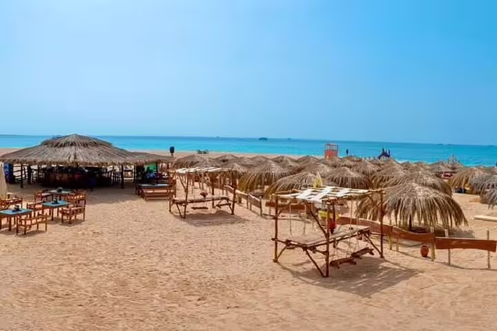Orange Bay Island beach huts and sunbeds on sandy shore, VIP boat snorkeling day trip from Hurghada