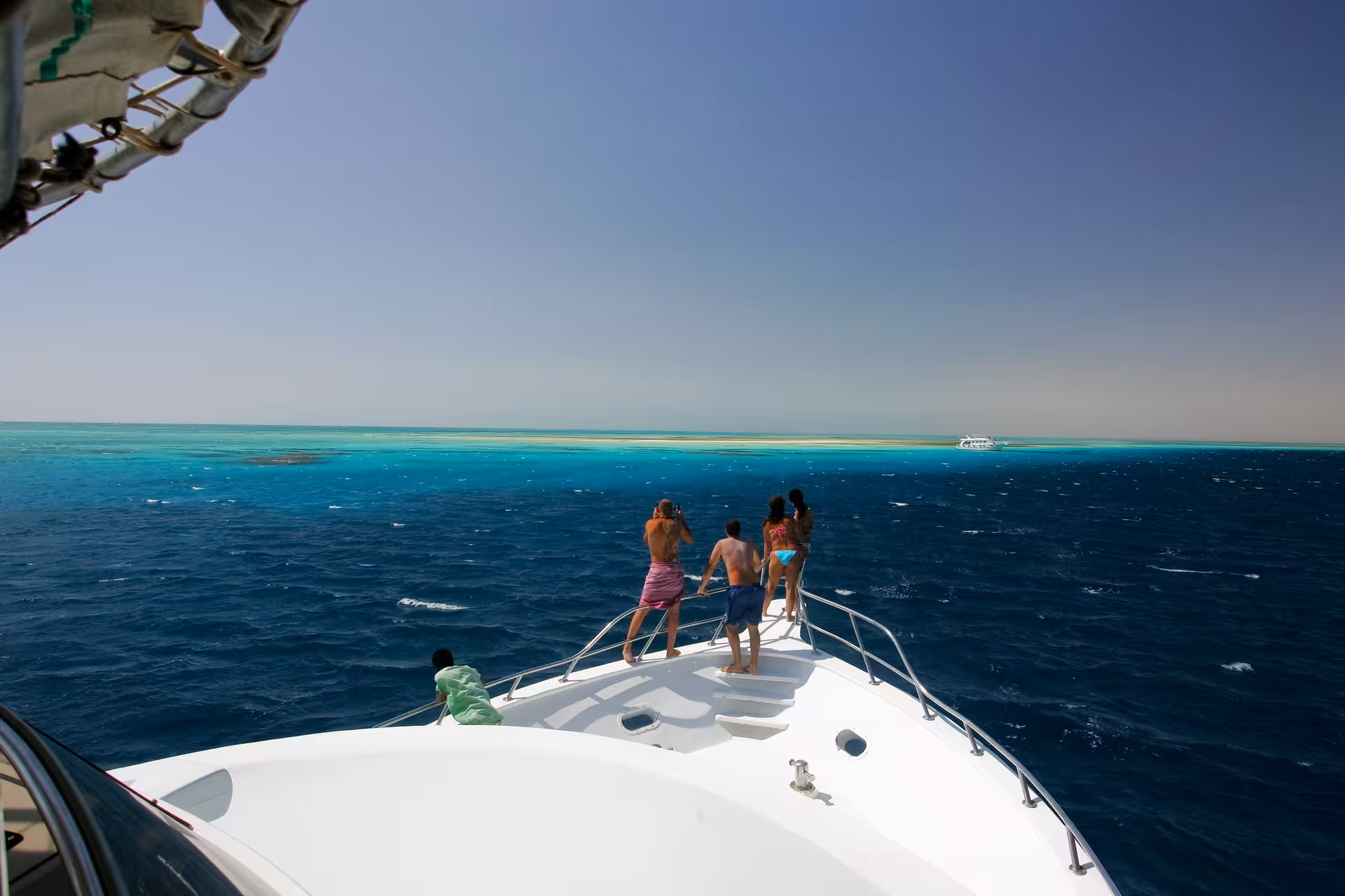 Guests on yacht bow heading to Orange Bay Island, Hurghada snorkeling excursion with lunch on the Red Sea