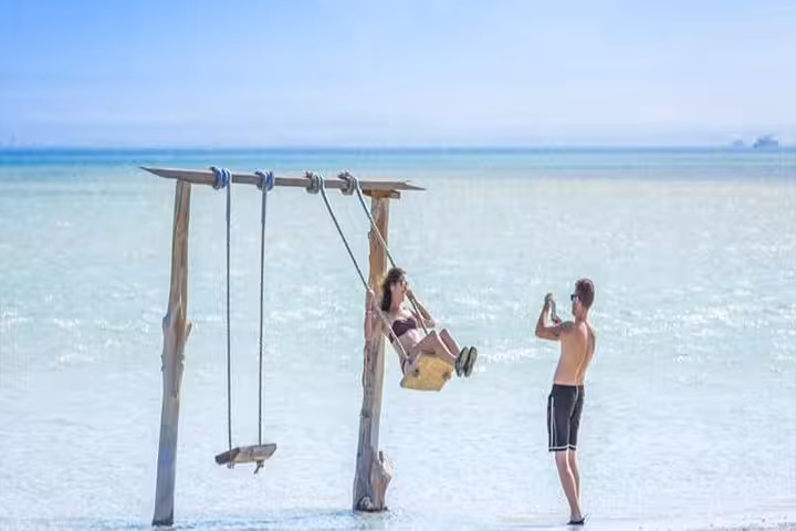 Orange Island Hurghada excursion with beach swing in shallow Red Sea water, perfect photo spot from El Gouna
