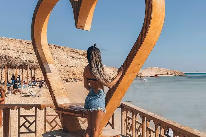 Tourist at Orange Island Hurghada heart photo spot by sandy beach and calm lagoon, Red Sea snorkeling day trip