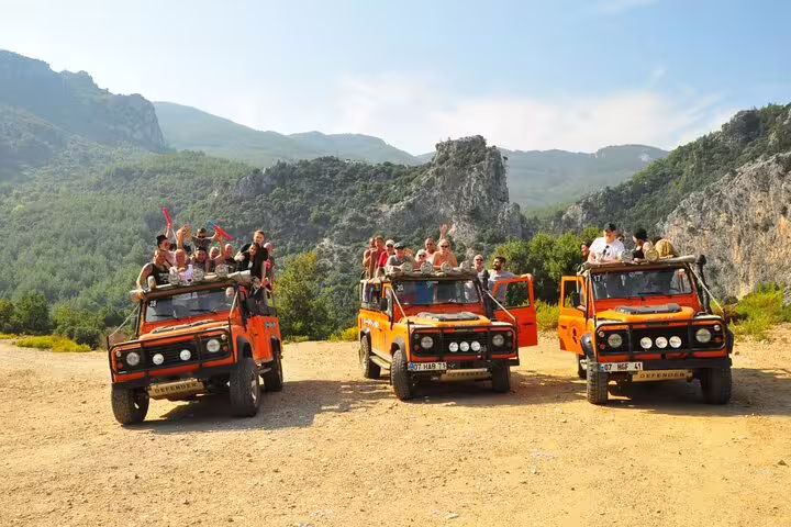 Vibrant orange jeeps with tourists ready for an exciting safari tour in the national park near Kusadasi.