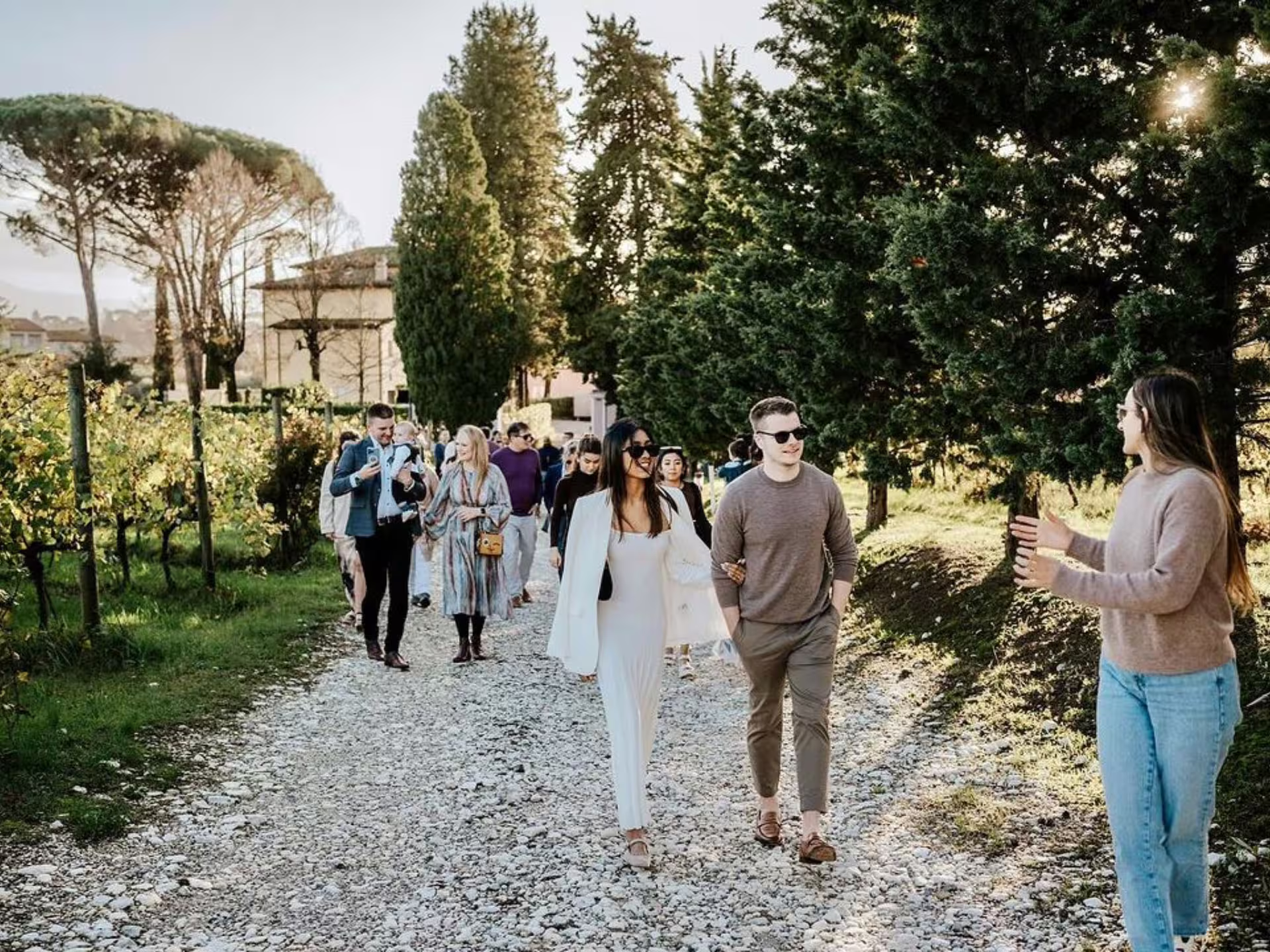 Group of tourists enjoying a guided walk through a lush vineyard during an organic winery tour in Lucca.