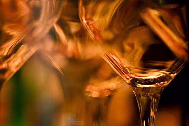 Elegant wine glasses reflecting warm lighting at an organic wine tasting session in Nice, showcasing vibrant ambiance.