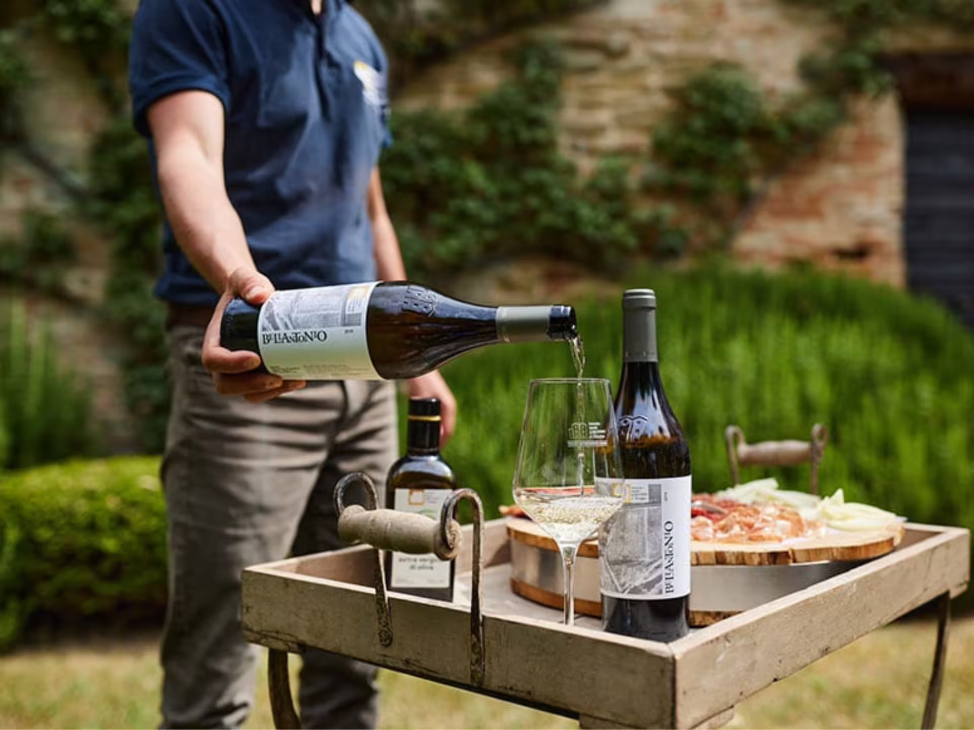Host pouring organic white wine beside local snacks during boutique winery visit with 5 wine tastings near Urbino