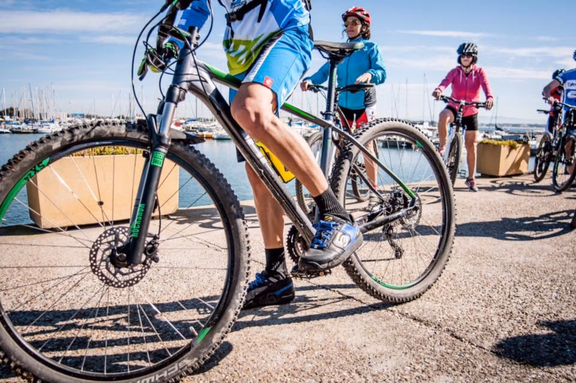 Cyclists on mountain bikes by the Torregrande coastline, enjoying breathtaking views of Oristano's marina.
