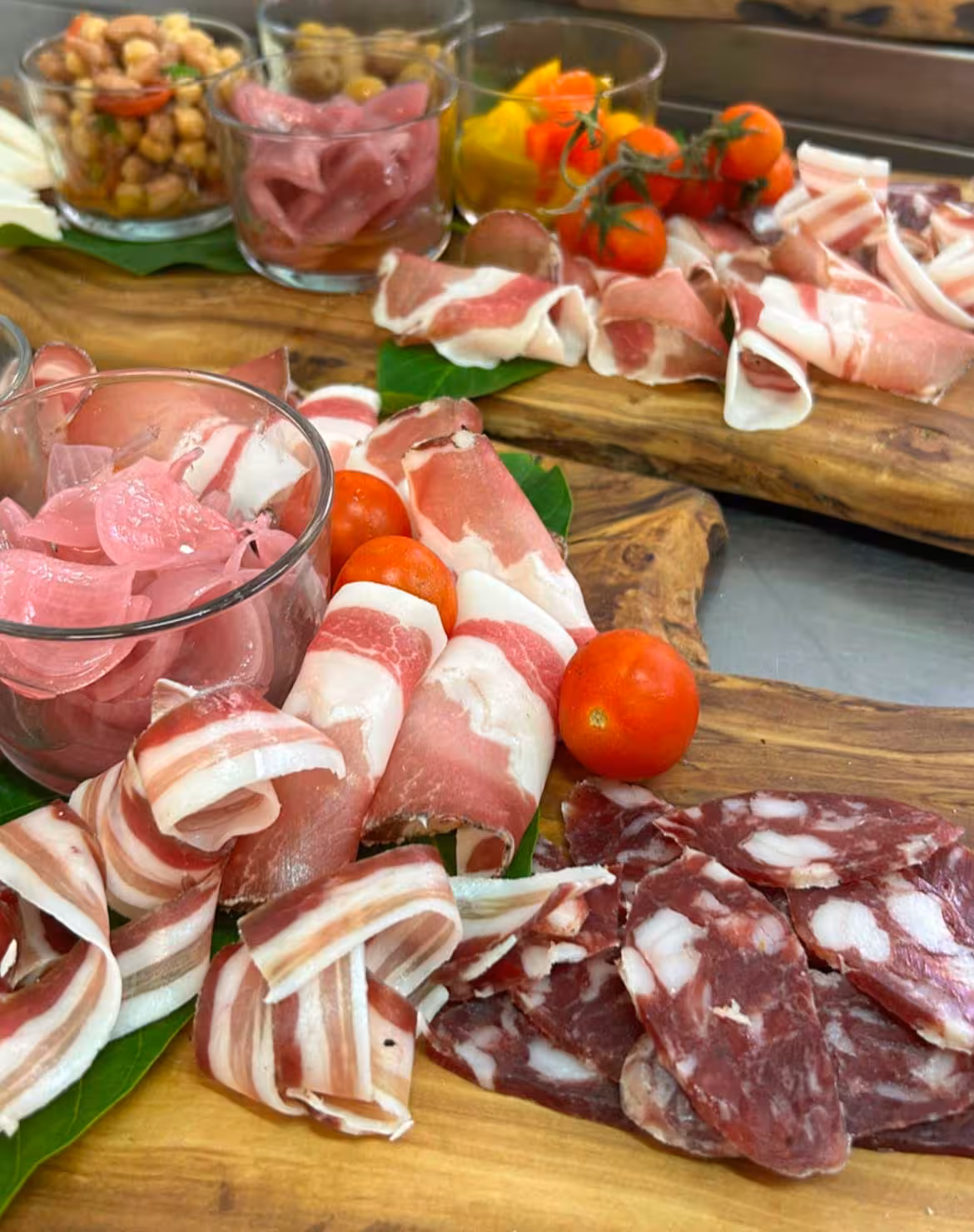Delicious assortment of meats and antipasti on a wooden platter at an Oristano farm tasting event.