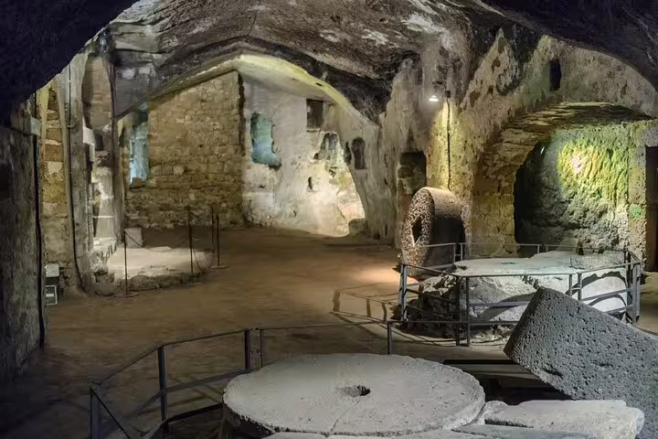 Ancient underground ruins with stone structures in Orvieto, featured in a private full-day guided tour from Rome with lunch.