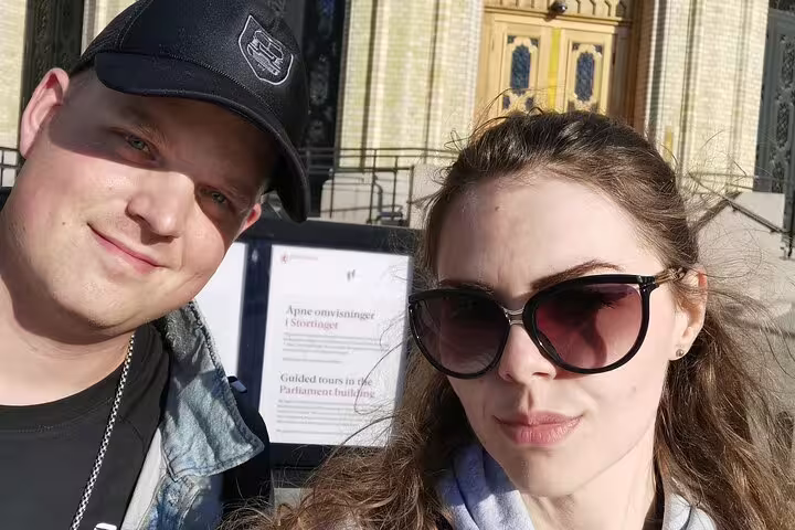 Couple taking a selfie in front of Oslo Parliament building on a guided walking tour