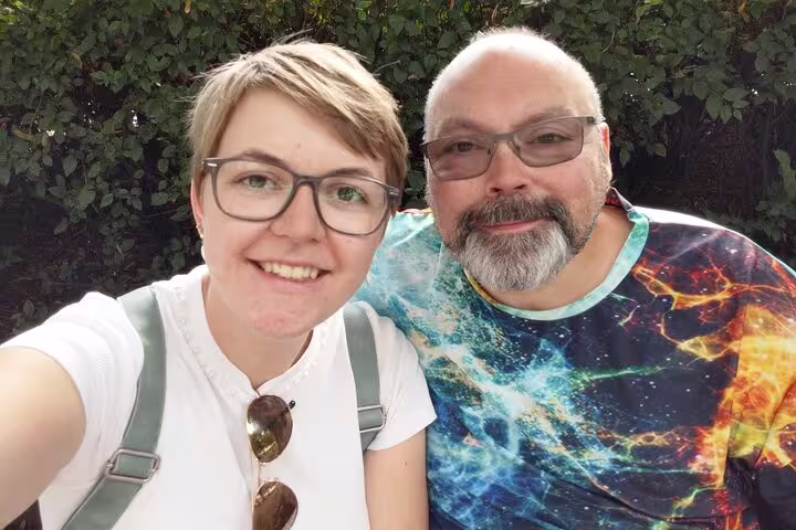 Two smiling visitors wearing glasses pose for a selfie outdoors during an Oslo walking tour