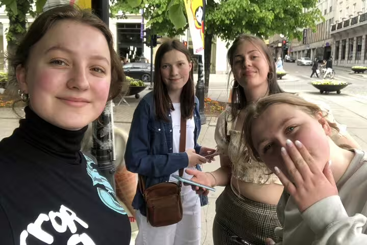 Four young women taking a selfie together on an Oslo city street during a walking tour