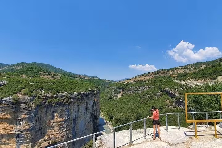 Visitor captures the expansive, green vistas of Osum Canyon from a high vantage point under a clear blue sky.