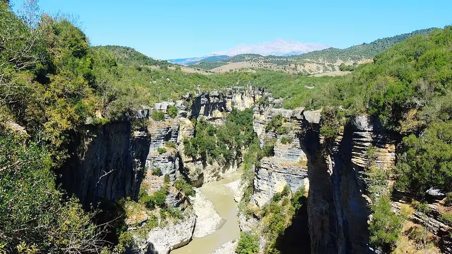 Stunning view of Osum Canyon in Albania, ideal for rafting adventures amidst lush greenery and rugged cliffs.