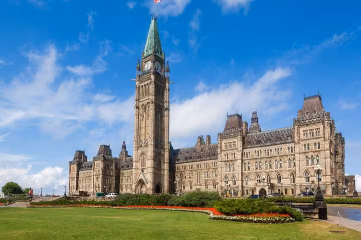 Parliament Hill Centre Block with Peace Tower and manicured gardens on a sunny day, Ottawa