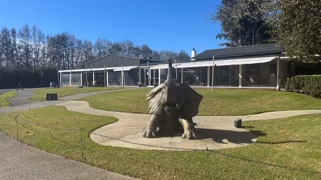 Outdoor sculpture of a majestic bird in a garden setting at an art tour destination, showcasing modern design.