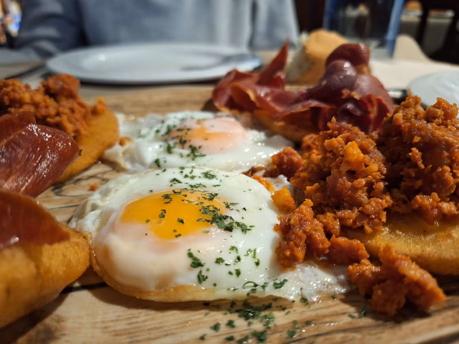 Traditional Asturian breakfast with fried eggs, cured meats, and chorizo, featured on Oviedo Food Tour.