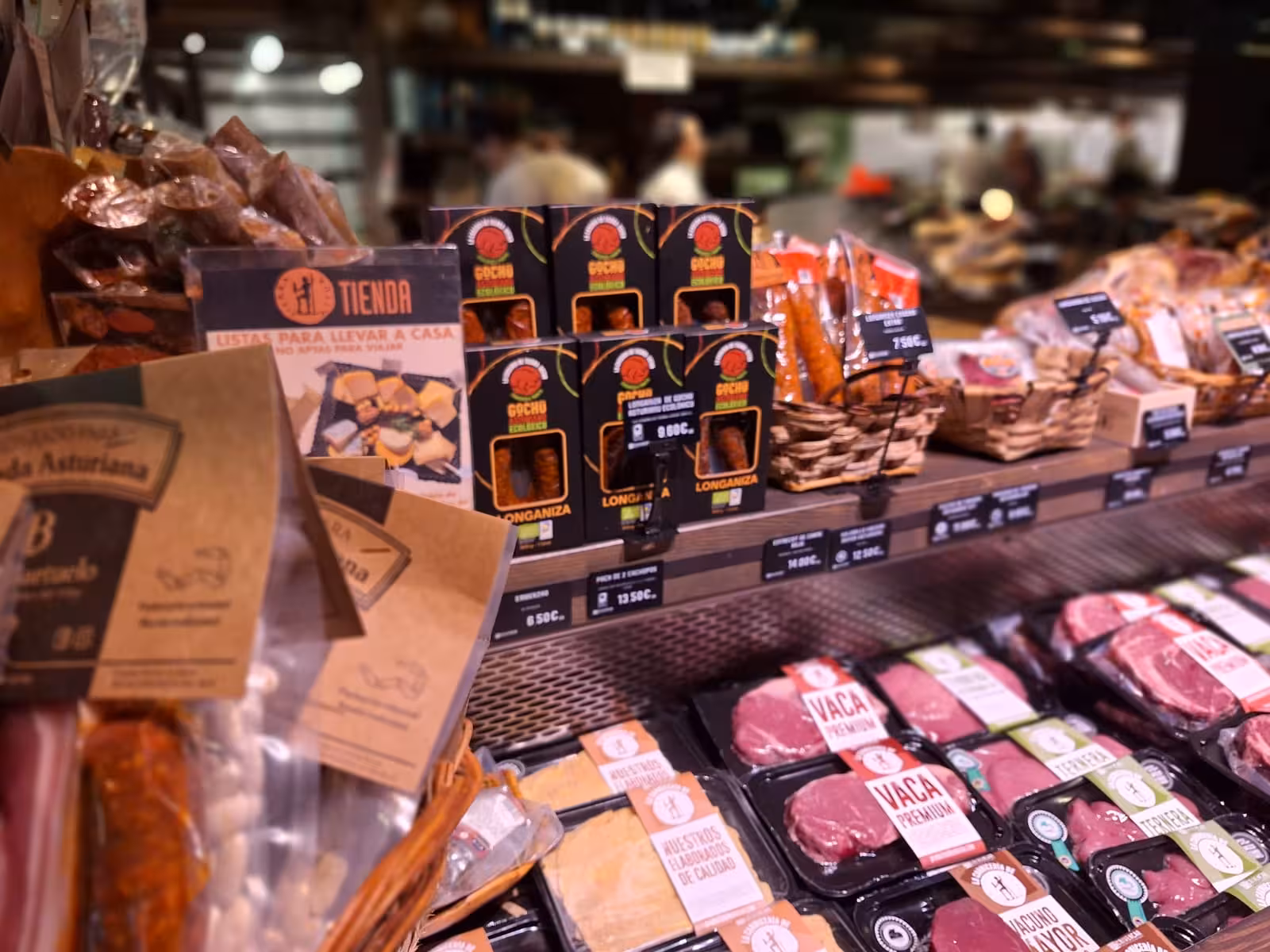 Display of Asturian meats and local delicacies in a market, highlighting tastes from the Oviedo food tour.