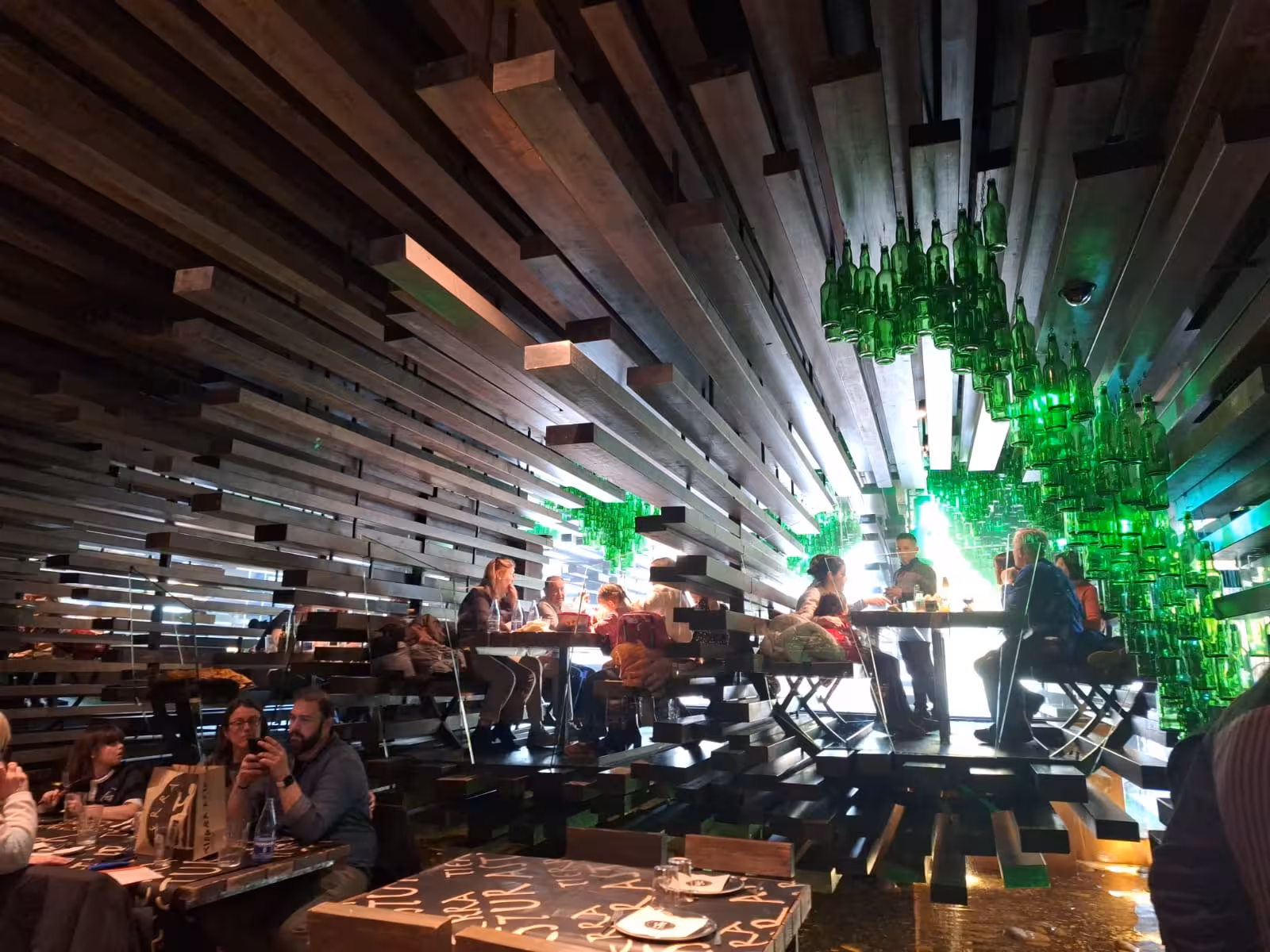 Unique interior of an Oviedo bar with green bottle decor, highlighting the Sidra experience on the food tour.