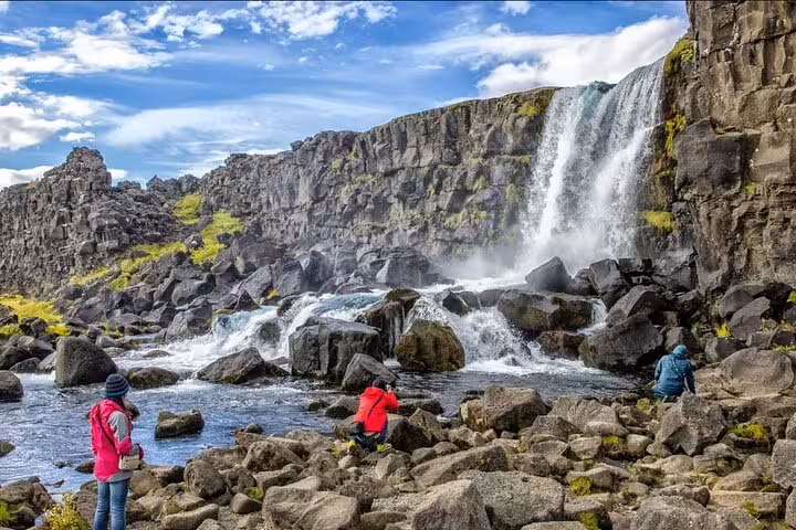 Tourists exploring Öxará river and Öxarárfoss waterfall on Iceland's Golden Circle tour