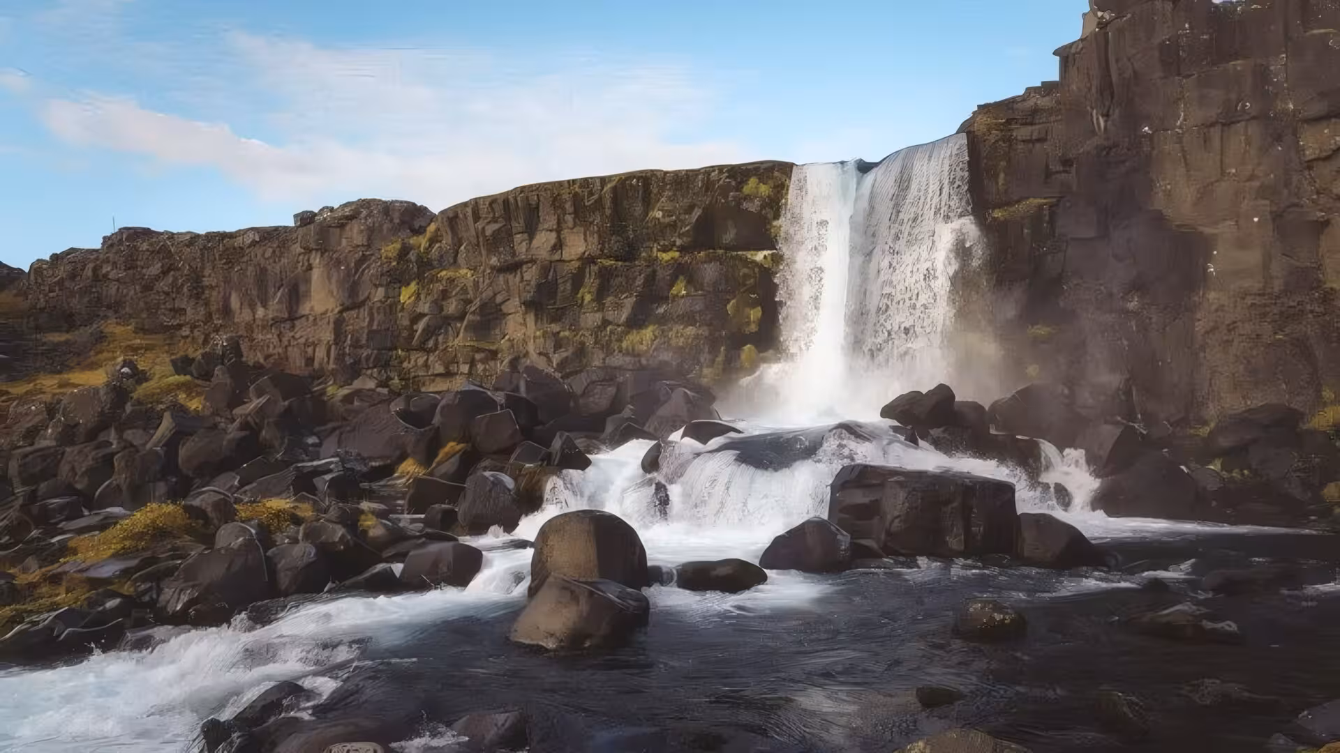 Öxará waterfall cascading over basalt cliffs into rocky river at Þingvellir, Iceland Golden Circle