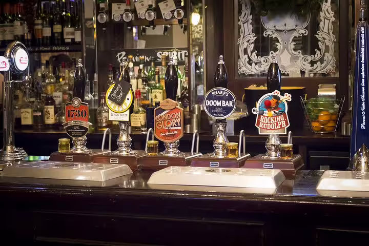 Traditional English pub bar with various beer taps in Oxford, perfect for a classic lunch stop on a London day trip tour.