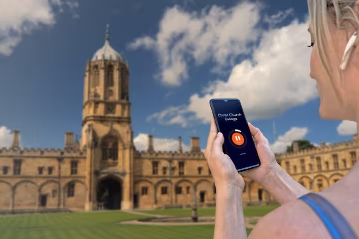 Tourist using GPS audio guide app at Christ Church College, Oxford self-guided walking tour