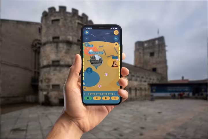 Hand holding smartphone displaying GPS walking tour app map with medieval castle walls in background