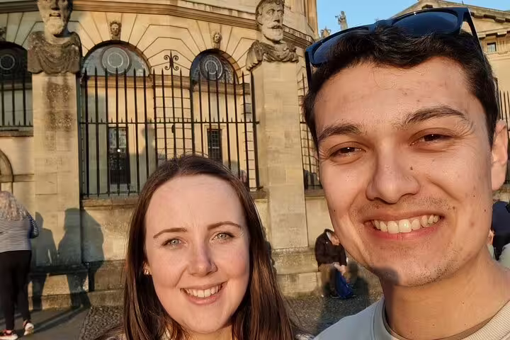 Smiling couple taking a selfie in front of a historic Oxford building on a walking tour