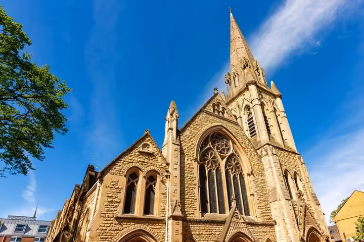 Gothic stone church with tall spire and ornate stained glass windows in Oxford city centre