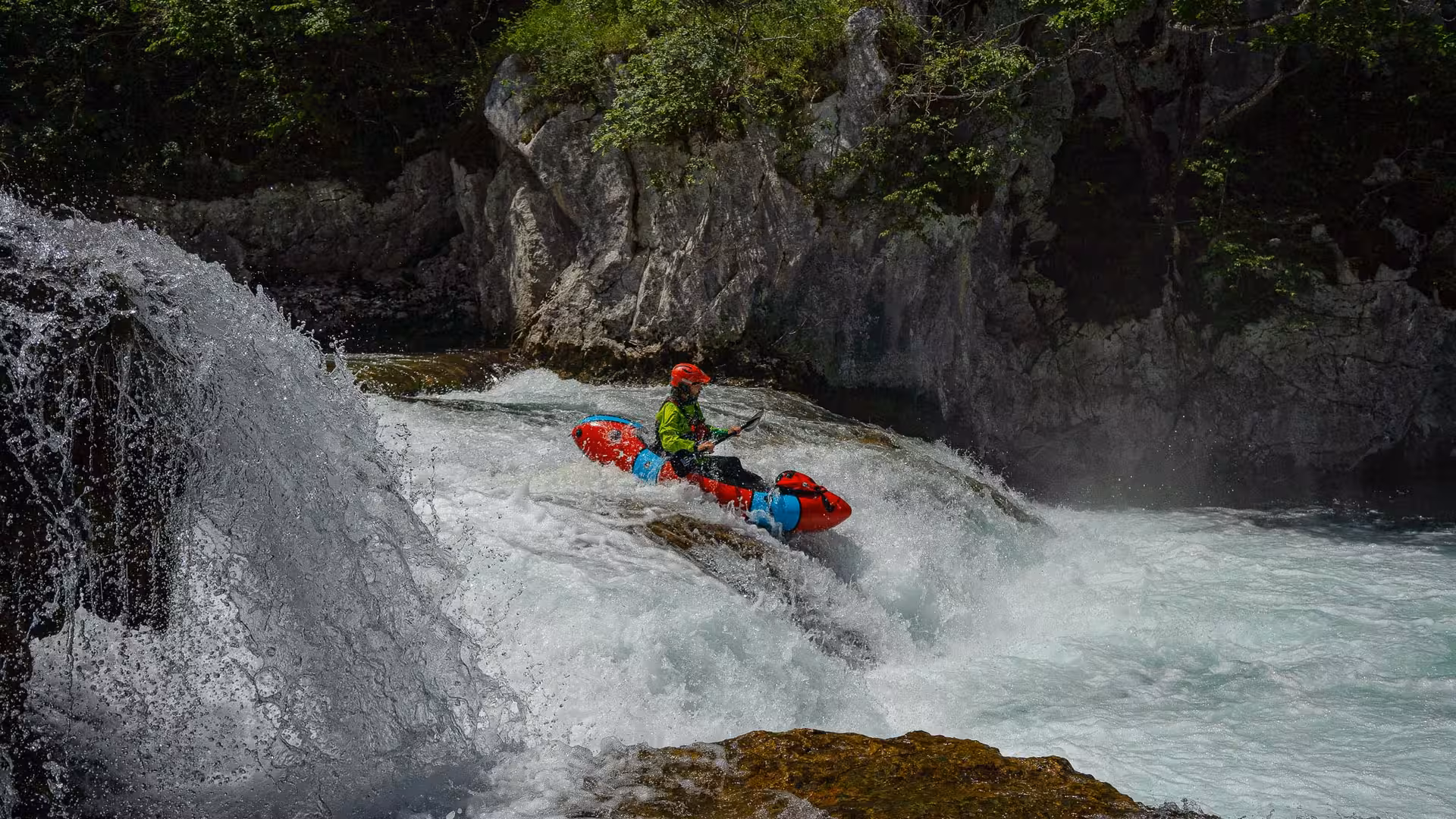Packrafter tackling a waterfall descent on the thrilling Mreznica River adventure tour.