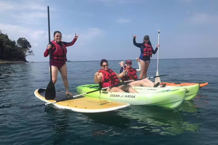 Group of friends paddleboarding and kayaking in Manuel Antonio, Costa Rica, fun-filled SUP adventure.