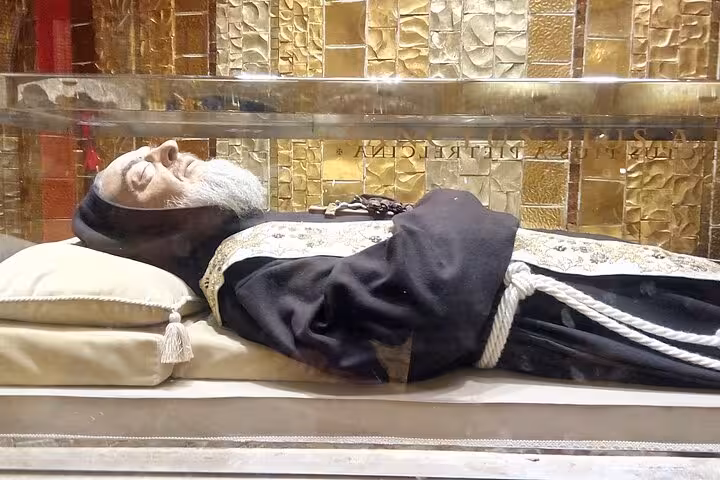 The preserved body of Padre Pio in a glass coffin at San Giovanni Rotondo, featured in a private tour from Rome.
