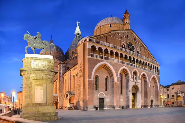 Evening view of Padua’s illuminated Basilica of Saint Anthony and equestrian statue on a private top sights walking tour