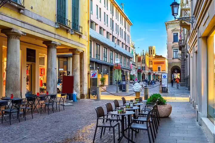Cobblestone pedestrian street in Padua with outdoor café seating and historic architecture