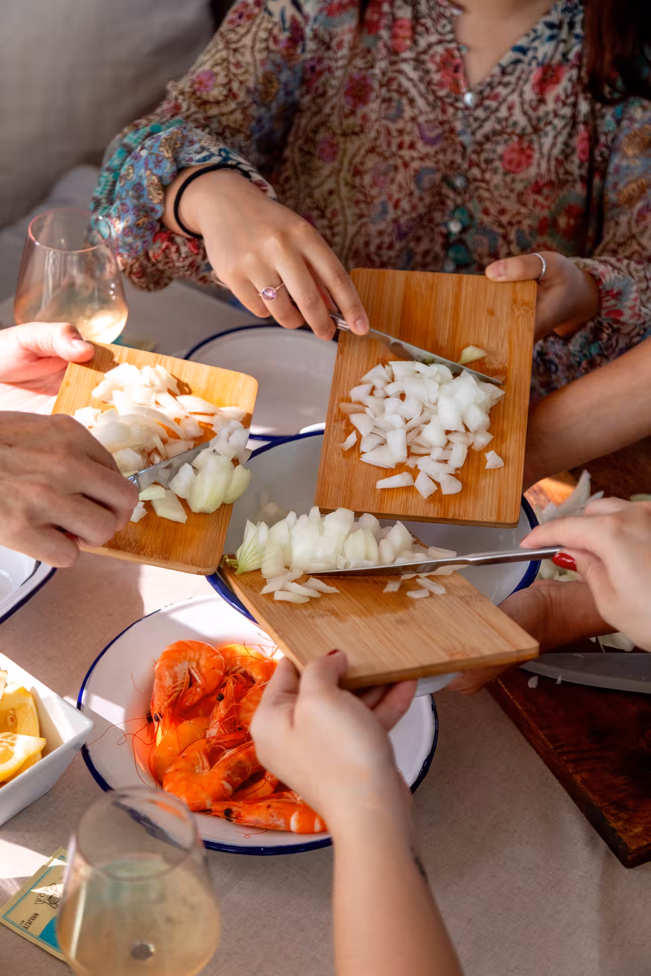 Guests chop onions on boards during Paella Masterclass, hands-on Spanish cooking class with seafood paella prep