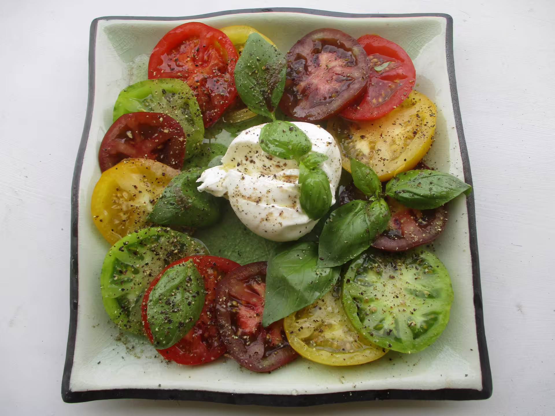 Colorful heirloom tomato and buffalo mozzarella caprese salad with fresh basil, a highlight of Paestum weekend food tours