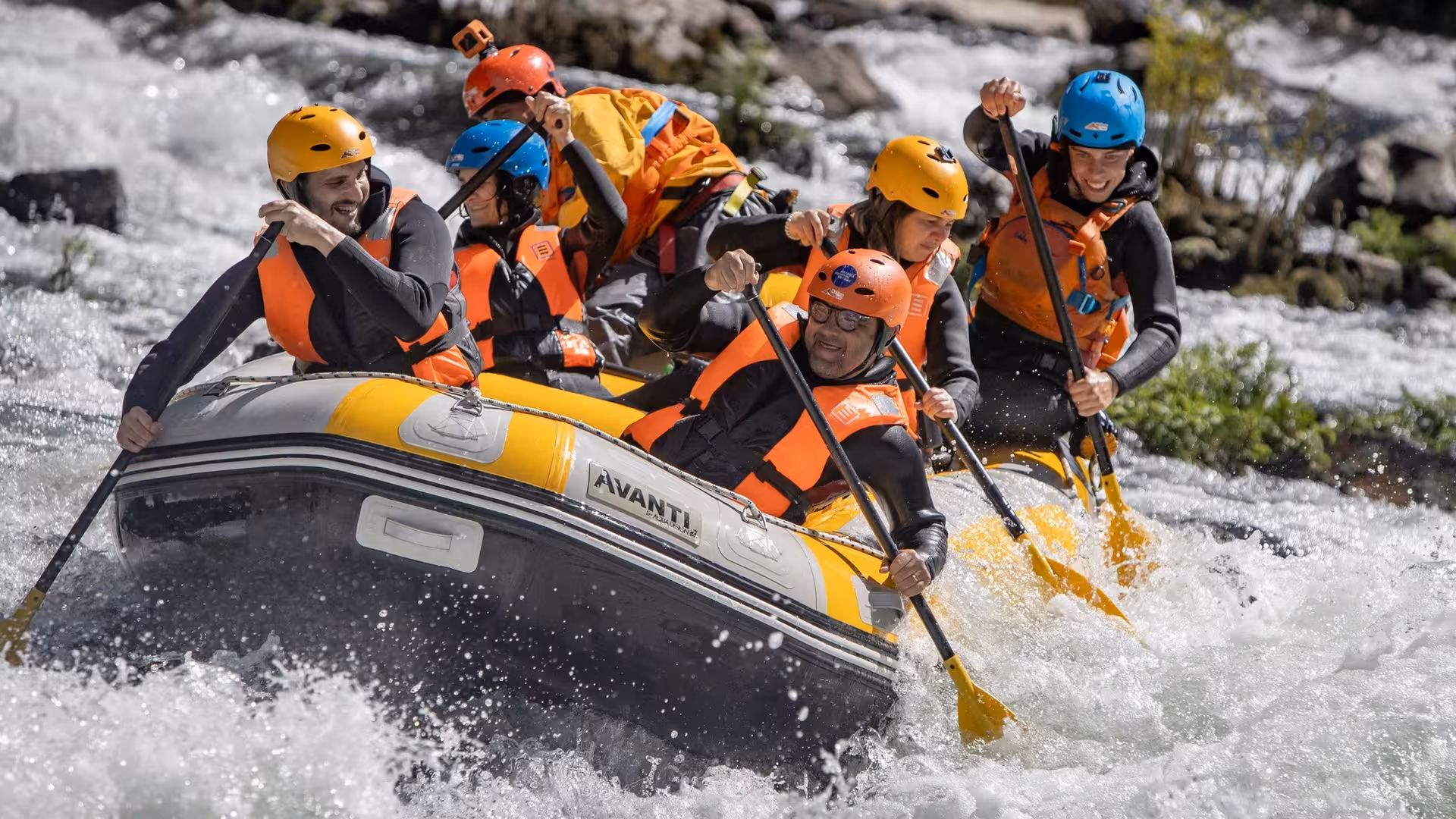 Action shot of Paiva River rafting day trip from Porto, Portugal, raft charging rapids with guide and crew