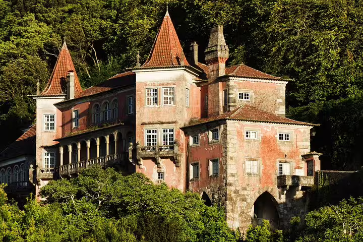 Majestic view of Palace Regaleira surrounded by lush greenery, featured in Sintra, Cascais & Estoril Private Tour package.