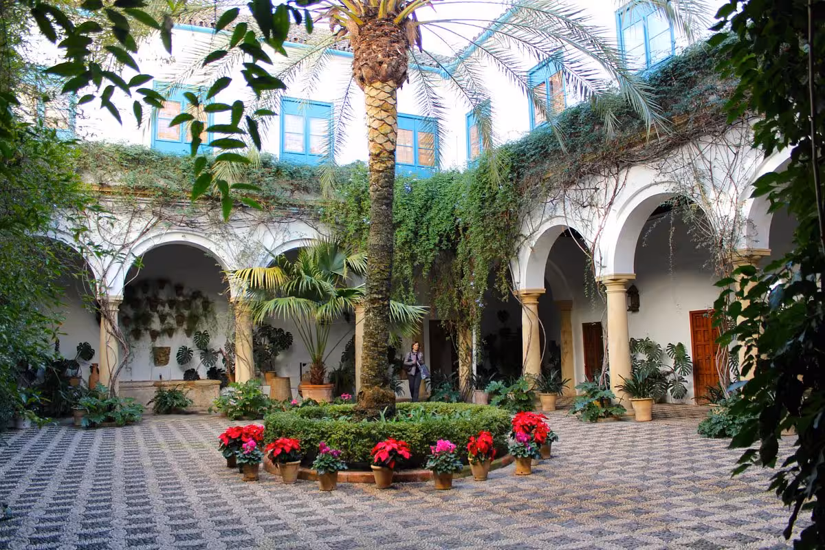 Palacio de Viana courtyard in Córdoba, Andalusian patio with palms, arches and flowers on guided visit