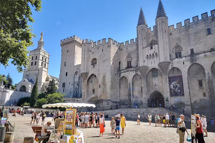 Palais des Papes in Avignon with bustling square, highlight of private full-day shore excursion city tour