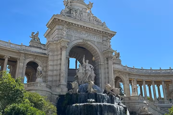 Palais Longchamp fountain in Marseille on a private driver sightseeing tour, grand arch and statues in sunshine