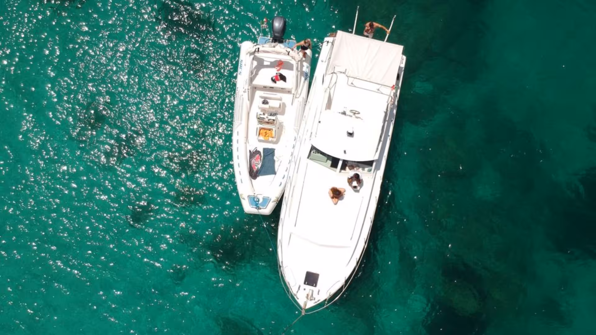 Aerial view of two boats sailing on the sparkling emerald waters of Palau, perfect for a scenic boat tour with lunch.