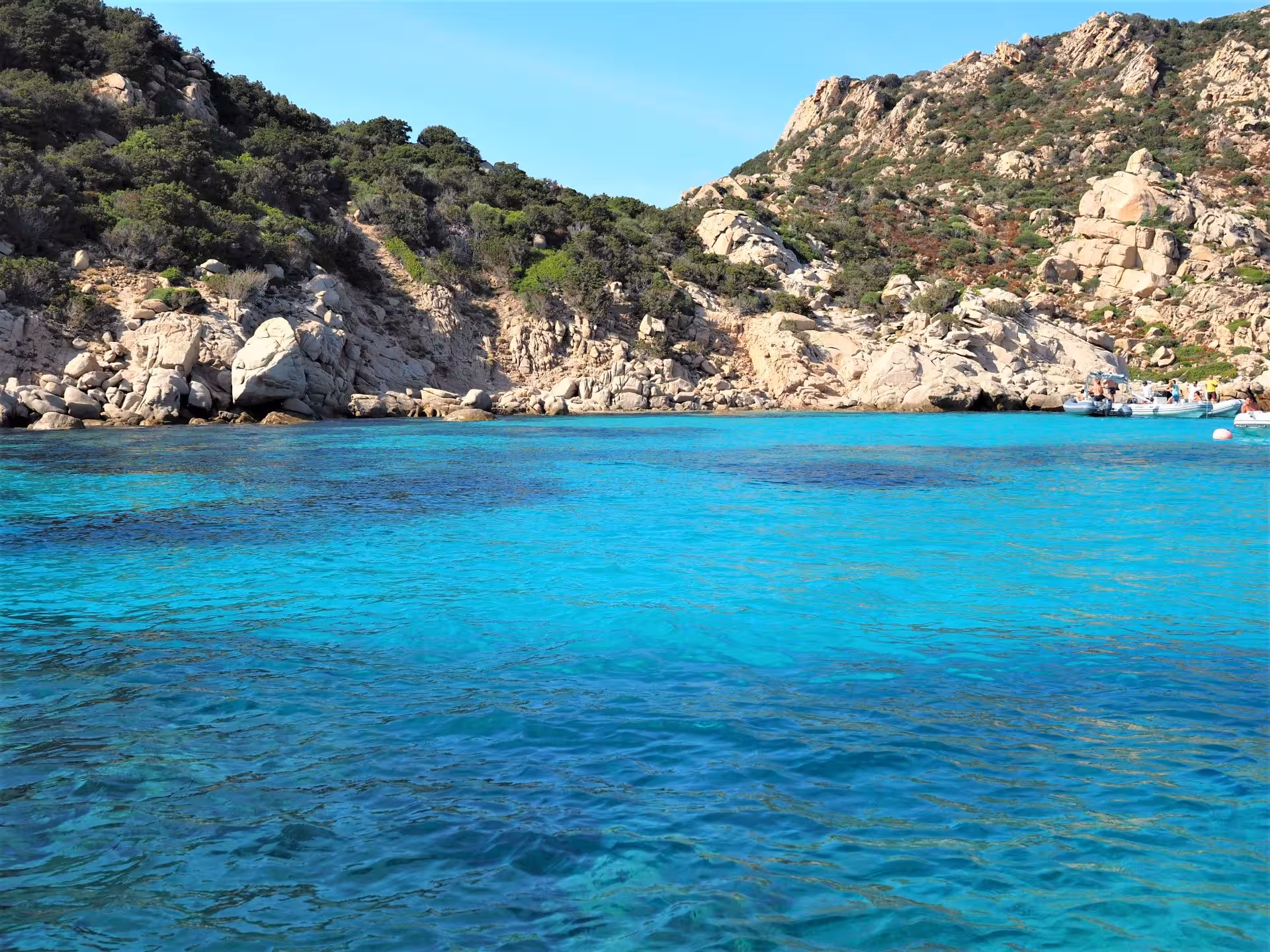 Scenic view of turquoise waters and rocky coastline during a La Maddalena dinghy tour from Palau.