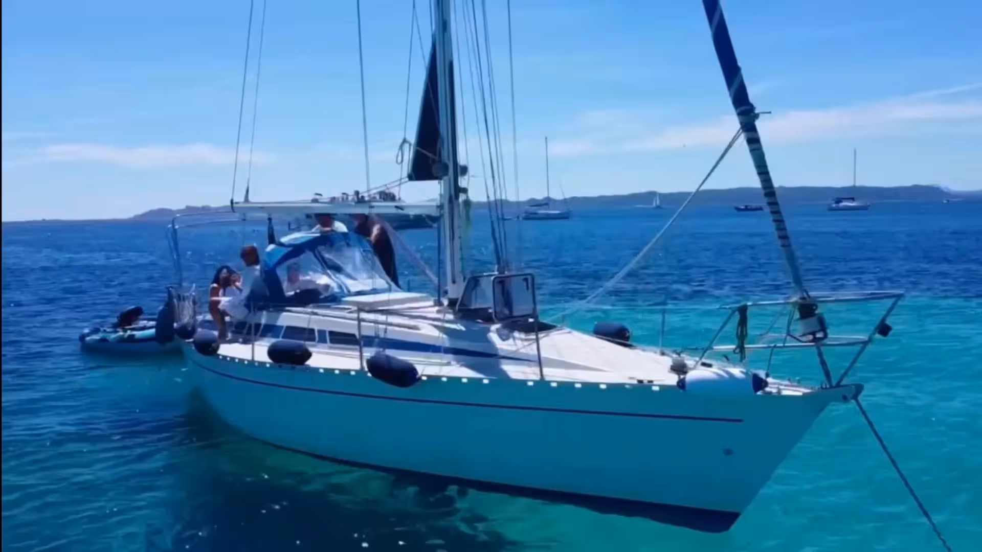 Sailing boat anchored in the clear turquoise waters of La Maddalena archipelago, perfect for a Palau excursion.