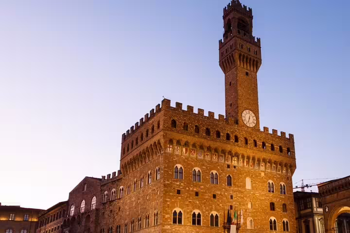 Palazzo Vecchio clock tower at dusk in Florence's Piazza della Signoria